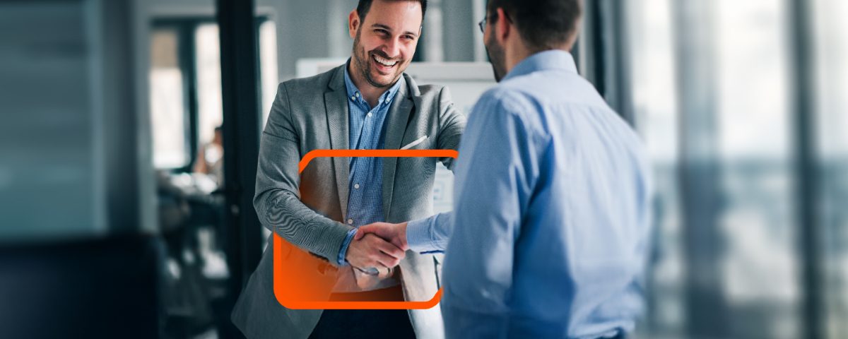 Two professionals shaking hands in a modern office setting